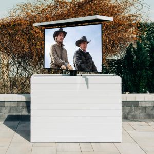 An outdoor hidden TV lift cabinet on an outdoor patio cladded in white shiplap.