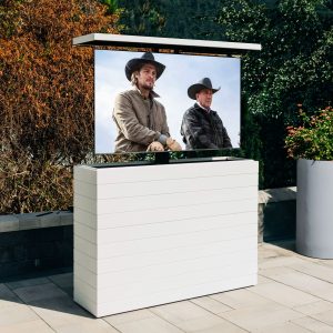 An outdoor hidden TV lift cabinet on a patio cladded in white shiplap.