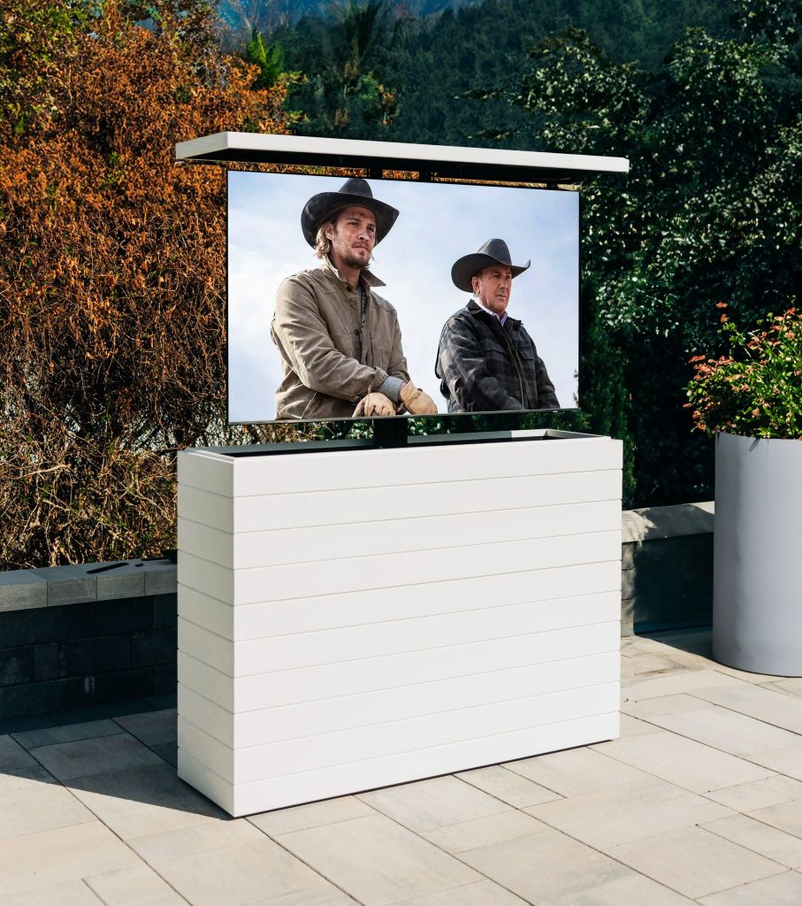 An outdoor hidden TV lift cabinet on a patio cladded in white shiplap.